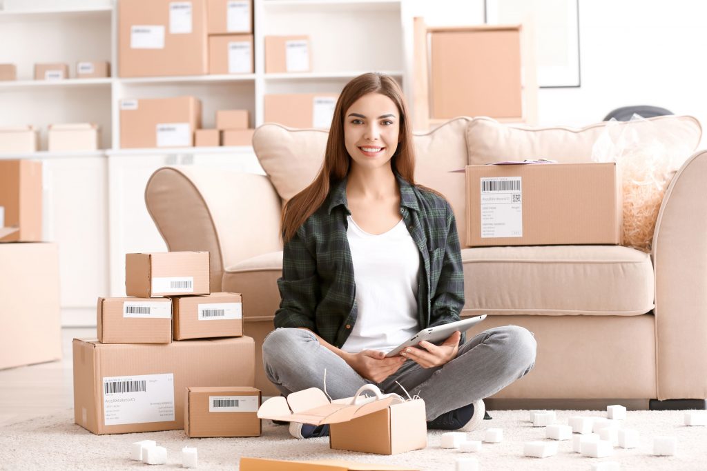 Business woman sitting in living room full of boxes